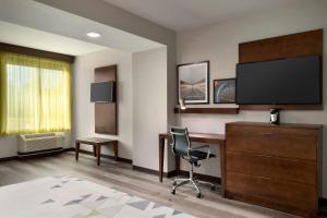 um quarto de hotel com uma secretária e uma televisão em La Quinta Inn & Suites by Wyndham Braselton em Braselton