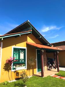 uma casa amarela com uma janela e um quintal em Casa Chale 10 Florianópolis em Florianópolis