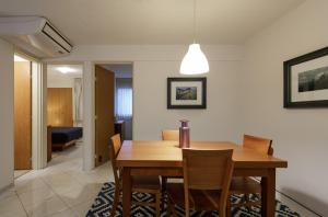 - une salle à manger avec une table et des chaises en bois dans l'établissement Apartamentos West End, à Guadalajara