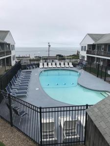 a large swimming pool with chairs and a swimming simulator at Oceanside Condos in Dennis Port