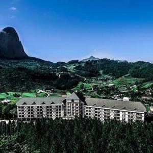 a large building on top of a hill with a mountain at Suíte Charmosa em Pedra Azul in Pedra Azul