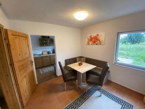 a dining room with a table and chairs and a kitchen at Ferienhaus Gutedel in Freyburg