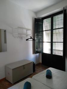 Habitación con cama y ventana grande. en Apartamento Centro Encarnación 1º I en Sevilla