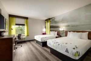 La Quinta Inn & Suites by Wyndham Braselton في براسيلتون: غرفة فندقية بسريرين ومكتب