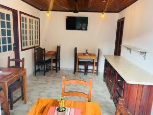a living room with tables and chairs and a counter at Pousada Marques in Paraty