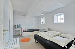 a white bedroom with a bed and a desk at Pension Slotsgaarden jels in Jels