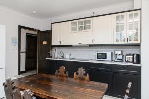 a kitchen with a wooden table and white cabinets at Villa Orient in Iława
