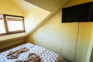 una piccola camera con letto e TV a schermo piatto di ATOS Srebrno jezero - Villa and Restaurant a Veliko Gradište