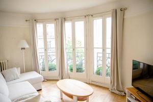 パリにあるRomantic Nestのリビングルーム(白いソファ、テーブル付)