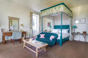 a bedroom with a bed and a couch and a table at The Talbot, Malton, North Yorkshire - The Coaching Inn Group in Malton