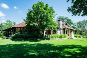 una casa con un albero in mezzo al cortile di ATOS Srebrno jezero - Villa and Restaurant a Veliko Gradište