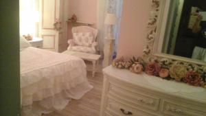 una camera con letto, specchio e sedia di Villa Di Miscio a SantʼAgata di Puglia