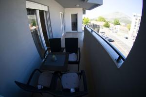 balcón con sillas y mesa y vistas a un edificio en Apartman Sunlight en Trebinje