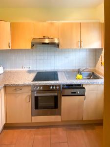 a kitchen with a stove and a sink at Ferienhaus "Hygge Friedrichskoog-Spitze" in Friedrichskoog