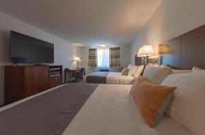 ein Hotelzimmer mit 2 Betten und einem Flachbild-TV in der Unterkunft Silver Inn in Kellogg
