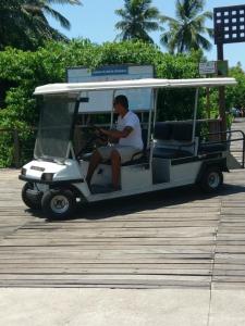 un hombre conduciendo un carrito de golf en un muelle en Vila Dos Lirios en Imbassai