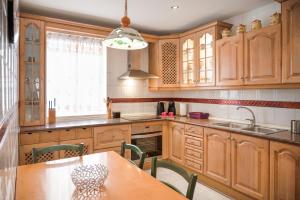 Una cocina con gabinetes de madera y una mesa con sillas. en Alhambra Boqueron 2, en Granada