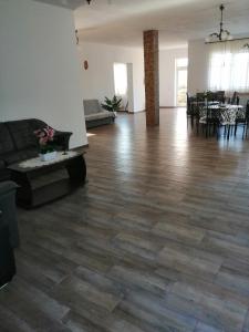 a living room with a couch and a wooden floor at Pensiunea Alex & Andry in Cordun +19 photos