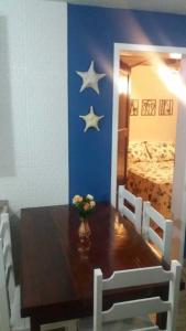 a dining room table with two stars on the wall at Village dos Pássaros Apartamento in Guarapari