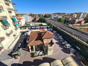 una vista aérea de un edificio con coches estacionados junto a un tren en Hotel Fiorella, en Senigallia