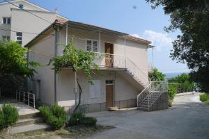 a white house with a staircase in front of it at Hostel Guesthouse Mira in Omiš