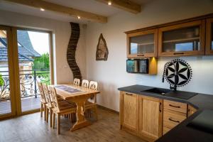 a kitchen with a table and chairs and a balcony at Willa911_Apartamenty in Rzepiska