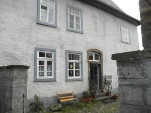 ein weißes Haus mit einer Bank davor in der Unterkunft Altstadthaus in Arnsberg