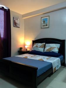 um quarto com uma cama com um edredão azul em Saekyung Village One em Mactan