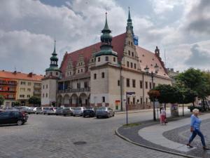 a large building with cars parked in a parking lot at Apart Brzeg in Brzeg