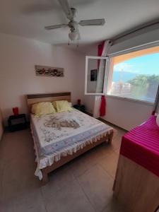 Un dormitorio con una cama y una ventana grande. en Residence Sejoina, en Calcatoggio