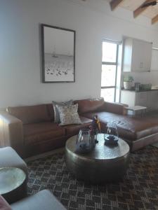 a living room with a leather couch and a coffee table at EGRETS` ĂRK in Gansbaai