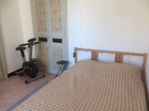 Appartement sur Sommières jusqu'à 6 personnes في سوميريس: غرفة نوم بسرير وجهاز جري بجانب باب