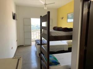 a room with two bunk beds and a window at Pousada Lourenço in Nazaré Paulista