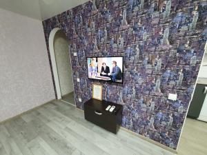 クロプィウヌィーツィクィイにあるApartment on Tarkovskogo 2のモザイク壁の壁掛けテレビ