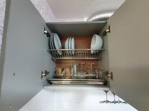 a kitchen with plates and glasses on a shelf at Apartment on Tarkovskogo 2 in Kropyvnytskyi