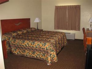 a hotel room with a bed and a window at Heritage Inn in Picayune