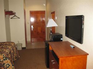 a hotel room with a bed and a flat screen tv at Heritage Inn in Picayune