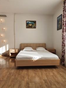 a bedroom with a bed and a wooden floor at Sophia Guesthouse in Adler