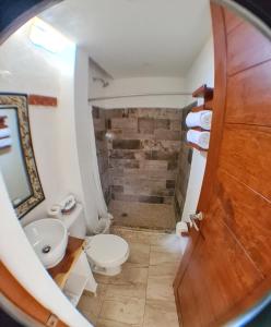 a bathroom with a toilet and a sink at Hotel Casa Shula, Acapulco in Pie de la Cuesta +22 photos