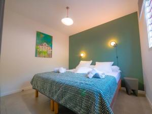 een slaapkamer met een bed met een blauwe en witte deken bij LES VILLAS GLACY in Les Trois-Îlets