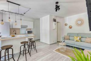Il dispose d'une cuisine et d'un salon avec un canapé et une table. dans l'établissement Le Vallombrosa T2, à Cannes