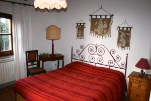 ein Schlafzimmer mit einem roten Bett mit einer roten Decke in der Unterkunft Tenuta Vitalonga in Ficulle