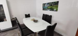 a white dining room with a white table and black chairs at 3 Zimmer Wohnung Köln-Hürth in Fischenich
