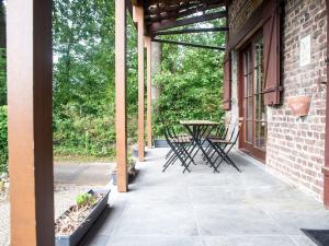 un patio con sillas y una mesa en un edificio de ladrillo en Splendid Villa in Vorsen, 