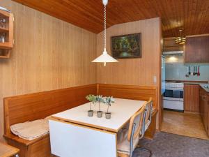 Mølbyにある4 person holiday home in R mの白いテーブル付きのキッチンが備わる客室です。