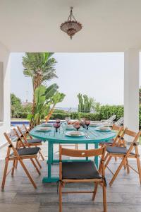 Cádiz punta carnero 1 في الجزيرة الخضراء: غرفة طعام مع طاولة وكراسي زرقاء