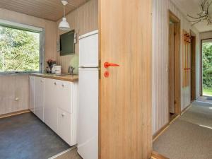 a kitchen with a white refrigerator and a window at 6 person holiday home in R m in Bolilmark