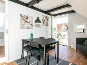 a dining room with a black table and chairs at Apartment Løkken in Løkken