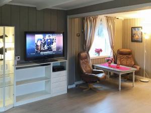 a living room with a tv and a table at Holiday home Vevelstad II in Vevelstad