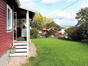una casa rossa con finestra e cortile di 4 person holiday home in VESSIGEBRO a Vessigebro